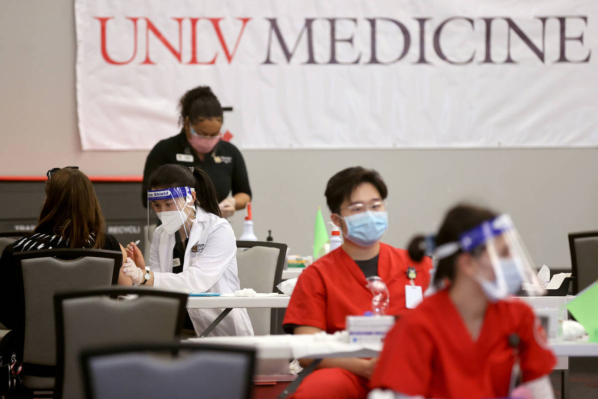 Angela Kong, left, a Nevada State College nursing student, gives a COVID-19 vaccine during a UN ...