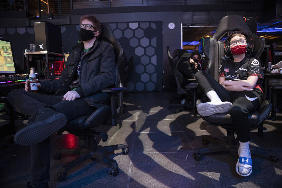 Players including Ryan Bourassa, 33, left, and Stone Loosvelt, 11, watch gameplay after losing ...
