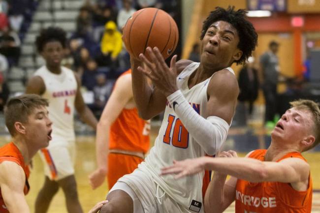 Bishop Gorman junior guard Zaon Collins (10) drives past Skyridge sophomore point guard Nick Ho ...