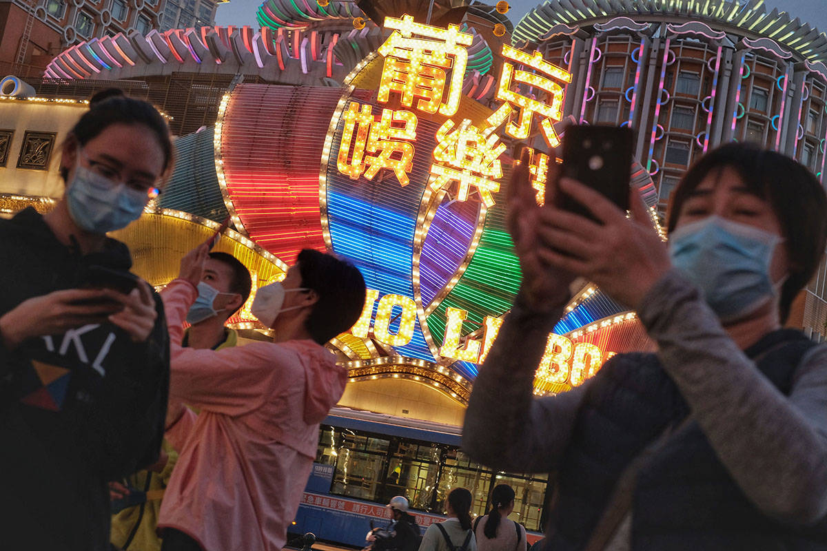 In this Jan, 23, 2020, photo released by Initium Media, tourists wearing masks, take photograph ...