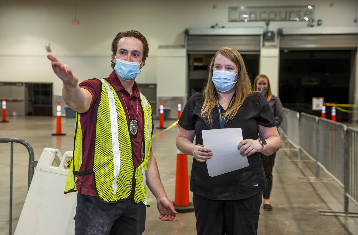 Chris Adams, left, directs Jessica Johnson as she checks in at the Southern Nevada Health Distr ...
