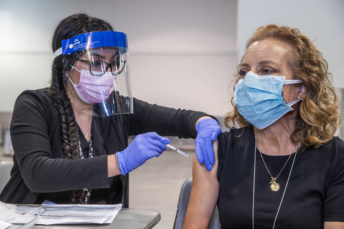 Registered nurse Jayde Fox, left, injects Margarita DeSantos with the Moderna vaccine at the So ...