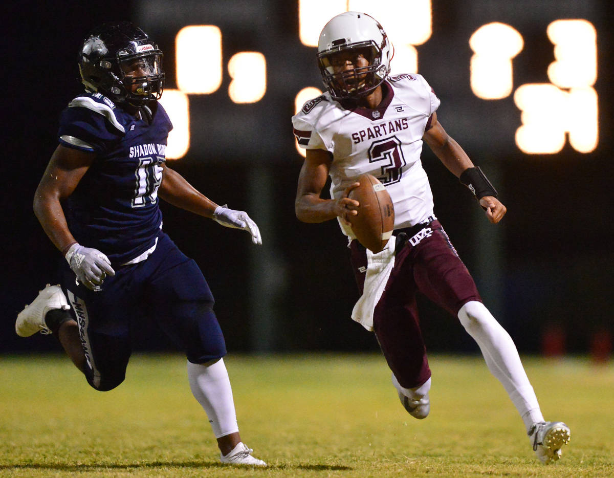 Cimarron-Memorial quarterback Branden Smith (3) is chased down by Shadow Ridge defensive end Is ...