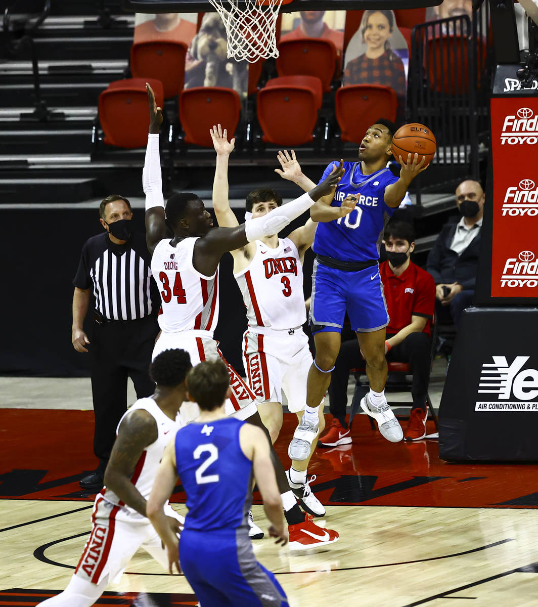 Air Force Falcons guard A.J. Walker (10) shoots under pressure from UNLV Rebels forward Cheikh ...