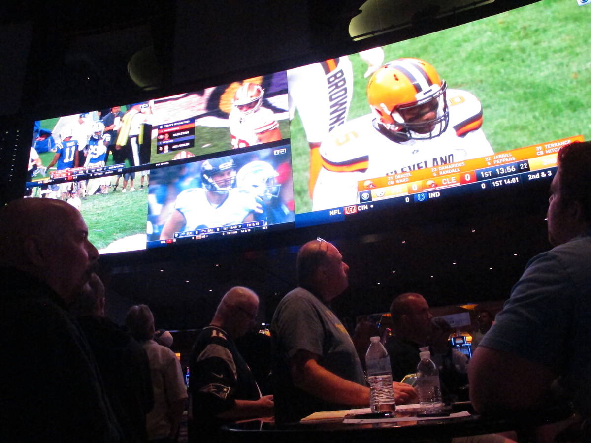 This Sept. 9, 2018 photo shows football fans watching the action on wall-mounted video screens ...