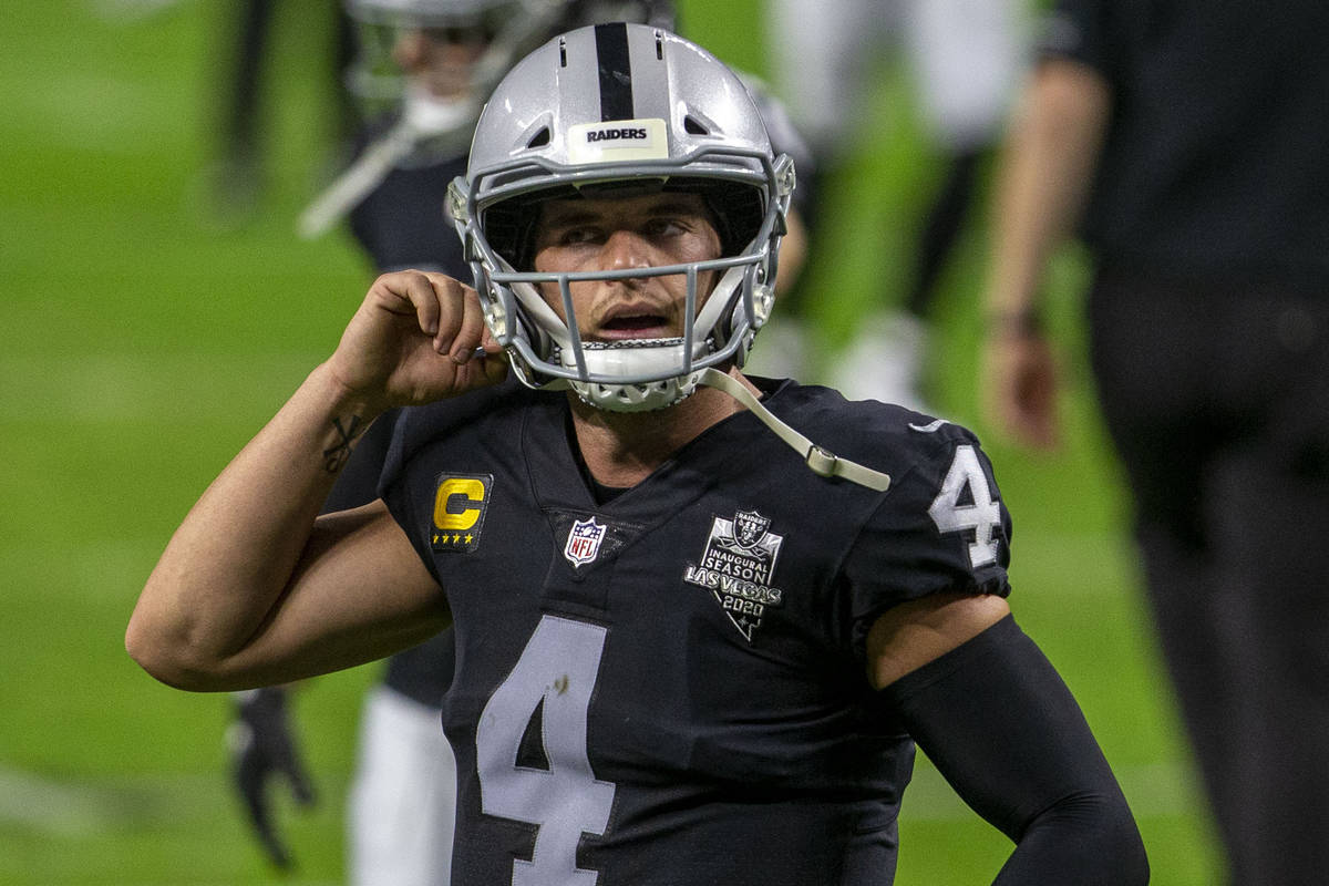 Raiders quarterback Derek Carr (4) removes his helmet after warm ups before an NFL football gam ...