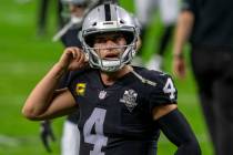 Raiders quarterback Derek Carr (4) removes his helmet after warm ups before an NFL football gam ...