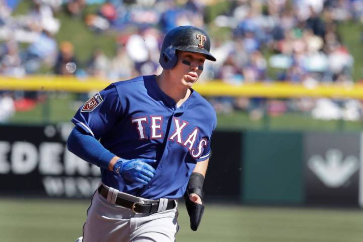 Texas Rangers' Drew Robinson heads to third during the second inning of a spring training baseb ...