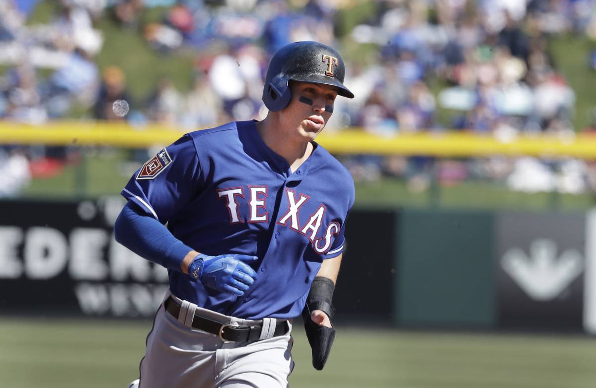 Texas Rangers' Drew Robinson heads to third during the second inning of a spring training baseb ...