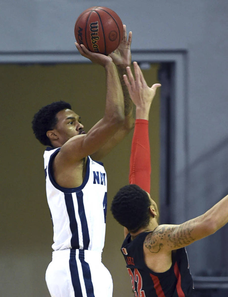 Nevada's Desmond Cambridge, Jr. shoots over UNLV 's Nicquel "Nick" Blake during the f ...