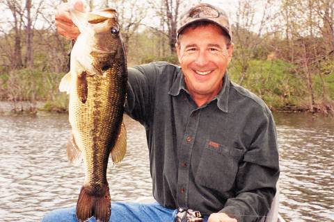 Bass Pro Shops founder Johnny Morris holds up a large bass, showing he is just as capable at ca ...