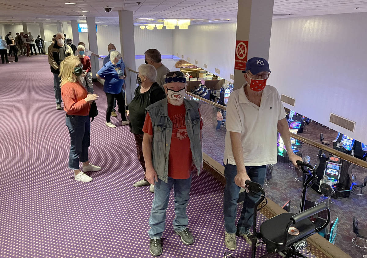 Terry Kutcher, 71, right, and Mike Smith, 71, both of Laughlin, wait in line for a COVID-19 vac ...