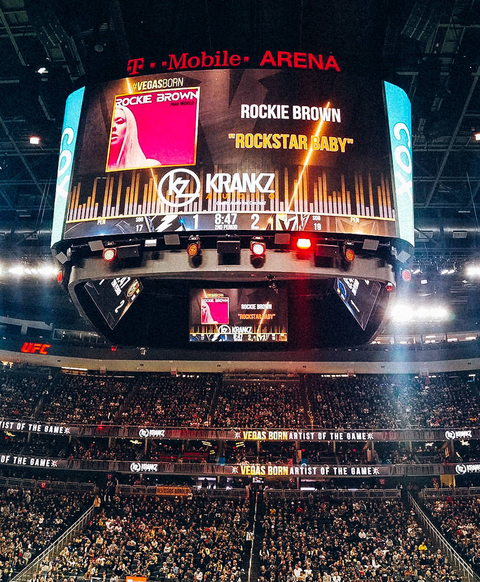 The T-Mobile Arena scoreboard is shown as Vegas Golden Knights music director Jake Wagner plays ...