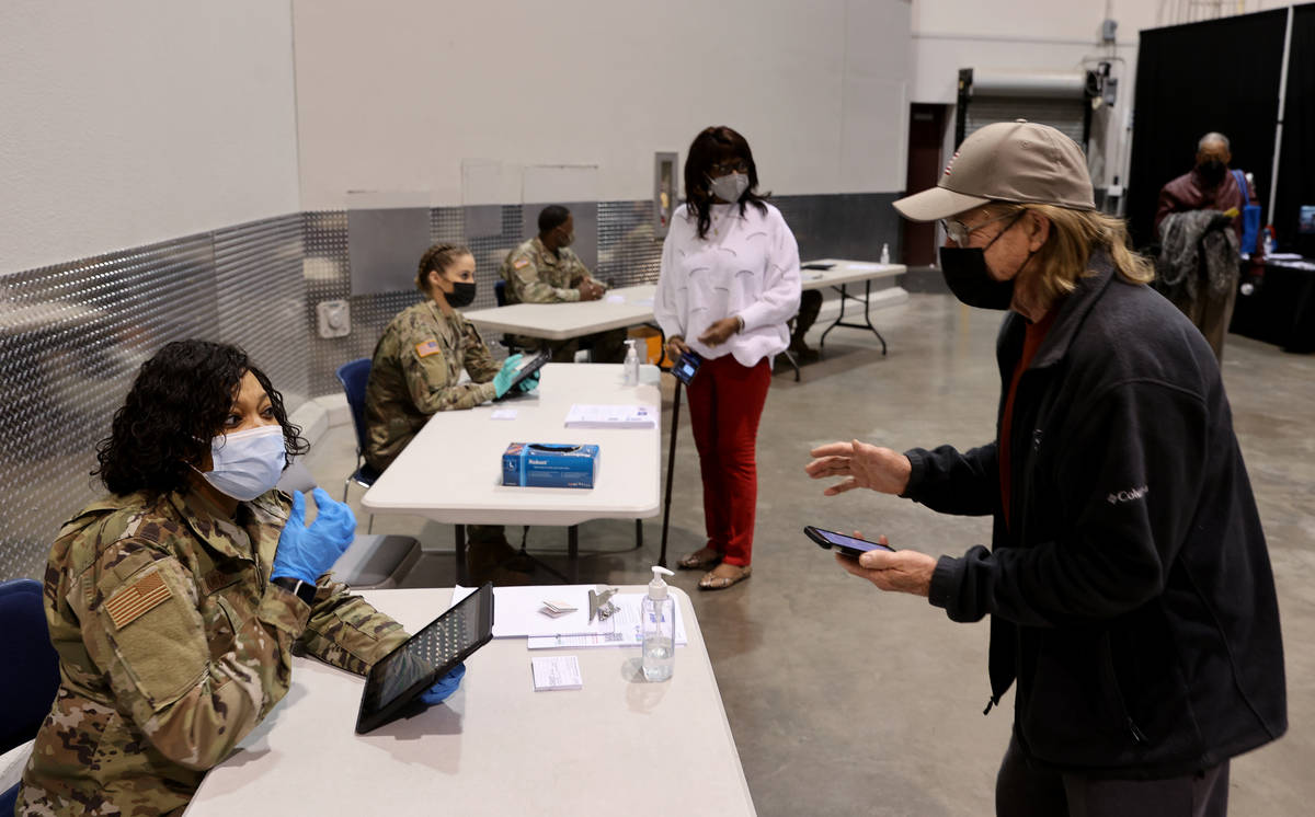 Mike Lucas, 70, of Henderson, checks in with Nevada National Guard Senior Airman Traesha Glover ...