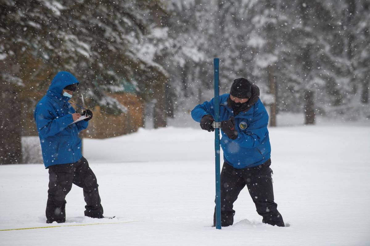 Assisted by Ramesh Gautam, left, Sean de Guzman, chief of snow surveys for the California Depar ...