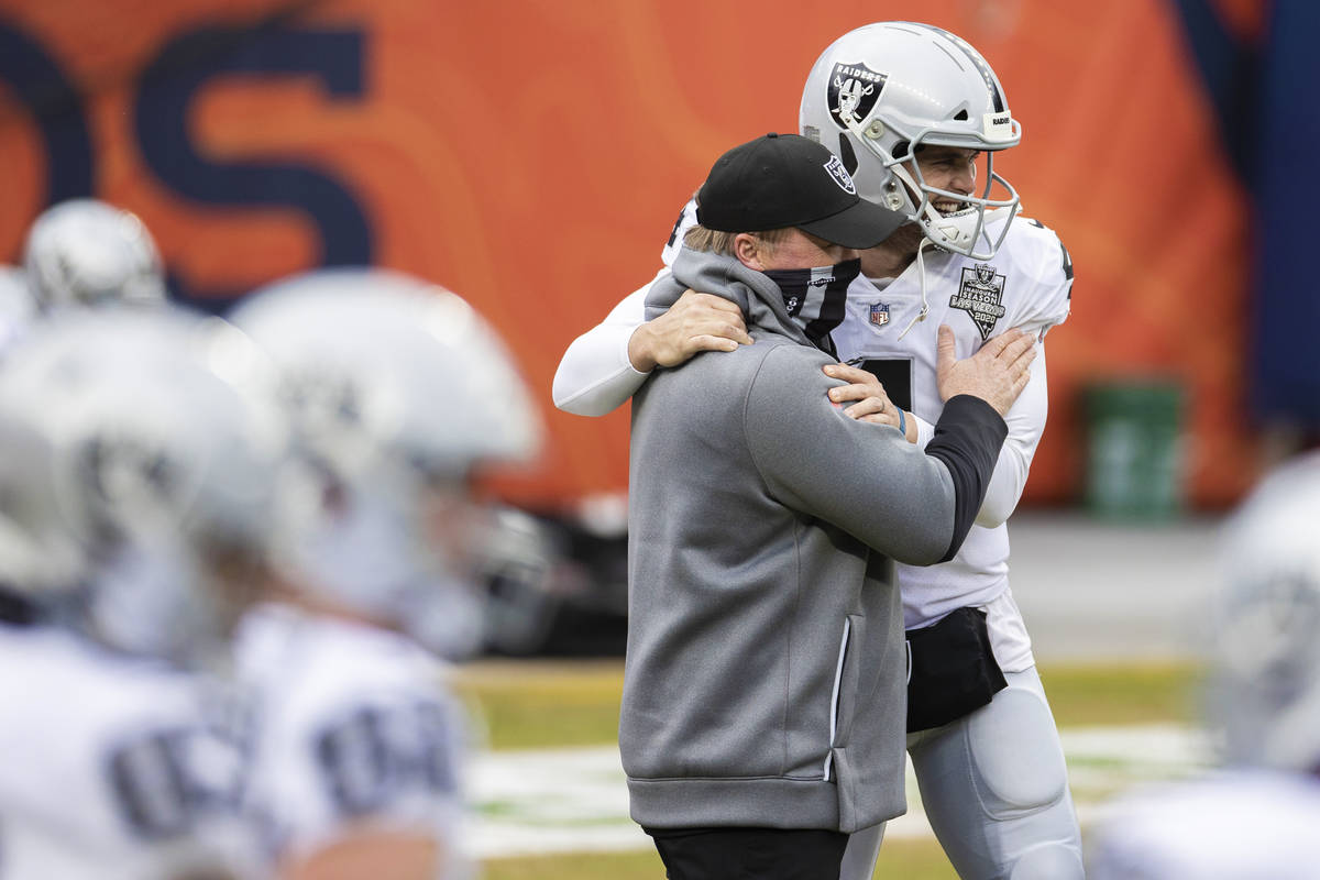 Raiders head coach Jon Gruden, left, hugs Raiders quarterback Derek Carr (4) during warm ups be ...