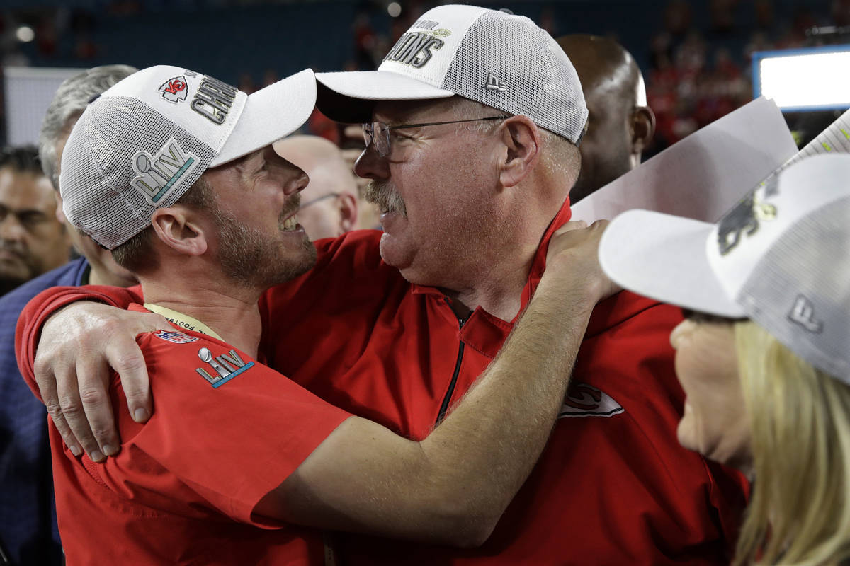 Kansas City Chiefs head coach Andy Reid embraces his son and is son Britt Reid, linebacker coac ...
