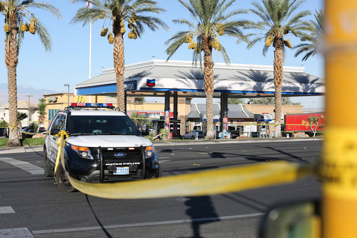 Police work the scene of a shooting that left one person dead at a gas station at the intersect ...