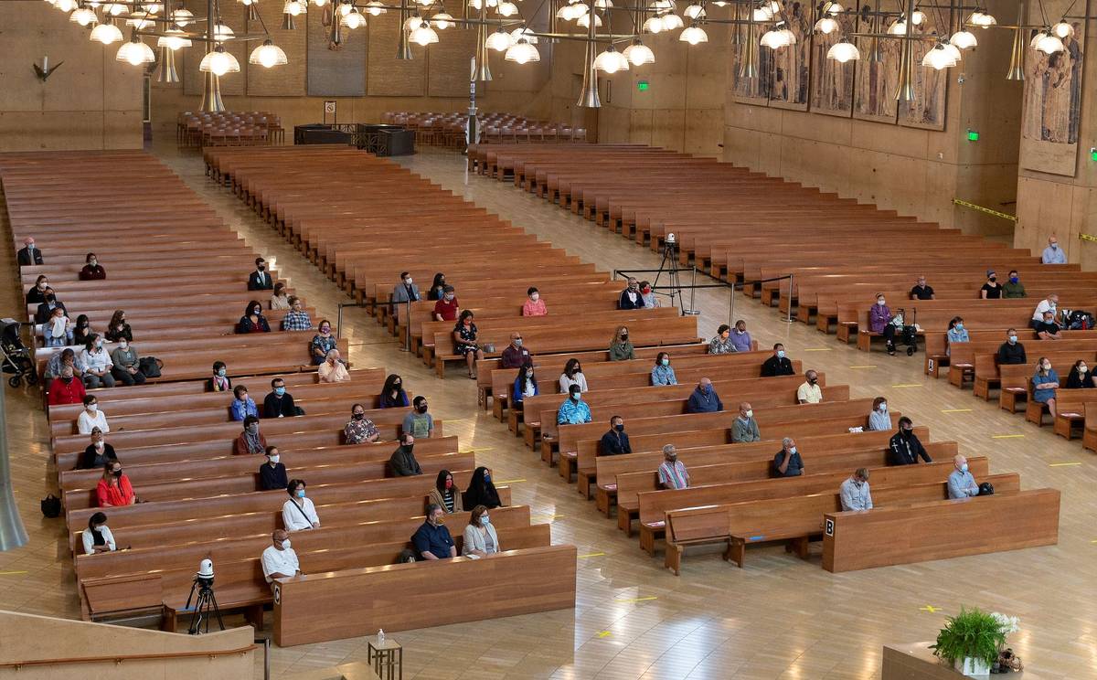 A hundred faithful listen to Los Angeles Archbishop Jose H. Gomez celebrate Mass at Cathedral o ...