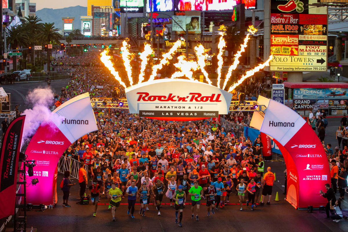 Runners leave the starting line beneath flames during the Rock 'n' Roll Marathon Sunday, Nov. 1 ...
