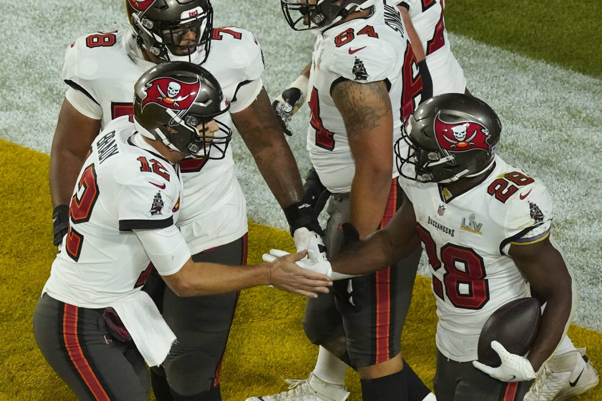 Tampa Bay Buccaneers' Leonard Fournette (28) celebrates his touchdown run with quarterback Tom ...