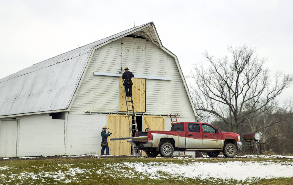 Men replace barn doors and a farm on Thursday, Feb. 4, 2021, near Southside, W.Va. (L.E. Baskow ...