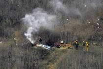 FILE - In this Jan. 26, 2020, file photo, firefighters work the scene of a helicopter crash in ...