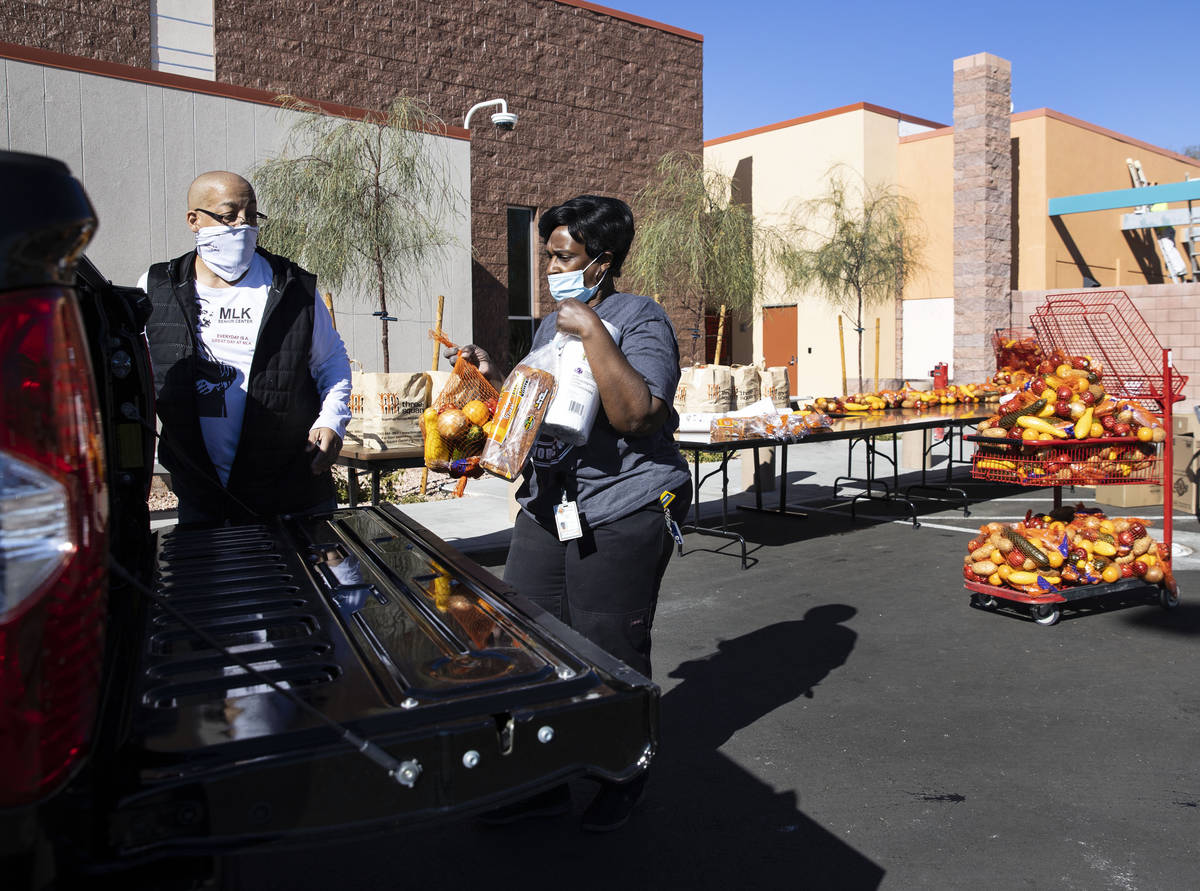 Brian Reese, left, and Archye Jett, a chef at the Martin Luther King Jr. Senior Center, load a ...