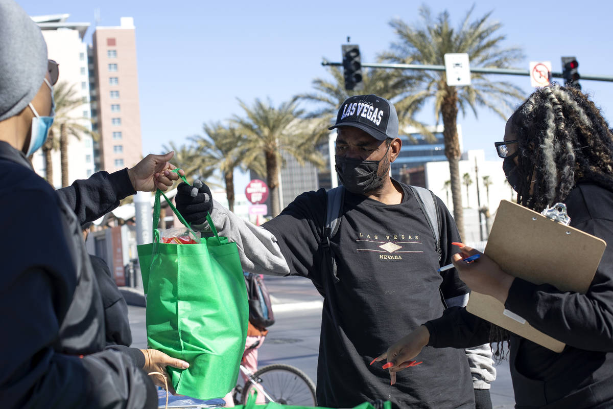 Lawrence Gene accepts a bag of groceries from New Era Las Vegas members during their Mary Wesle ...