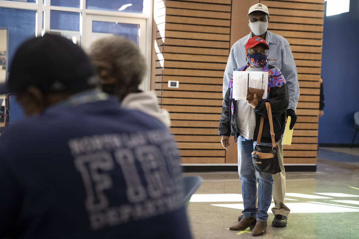 Ernest Conner, rear, and his wife Henrietta Peterson, wait in line to get the COVID-19 vaccine ...