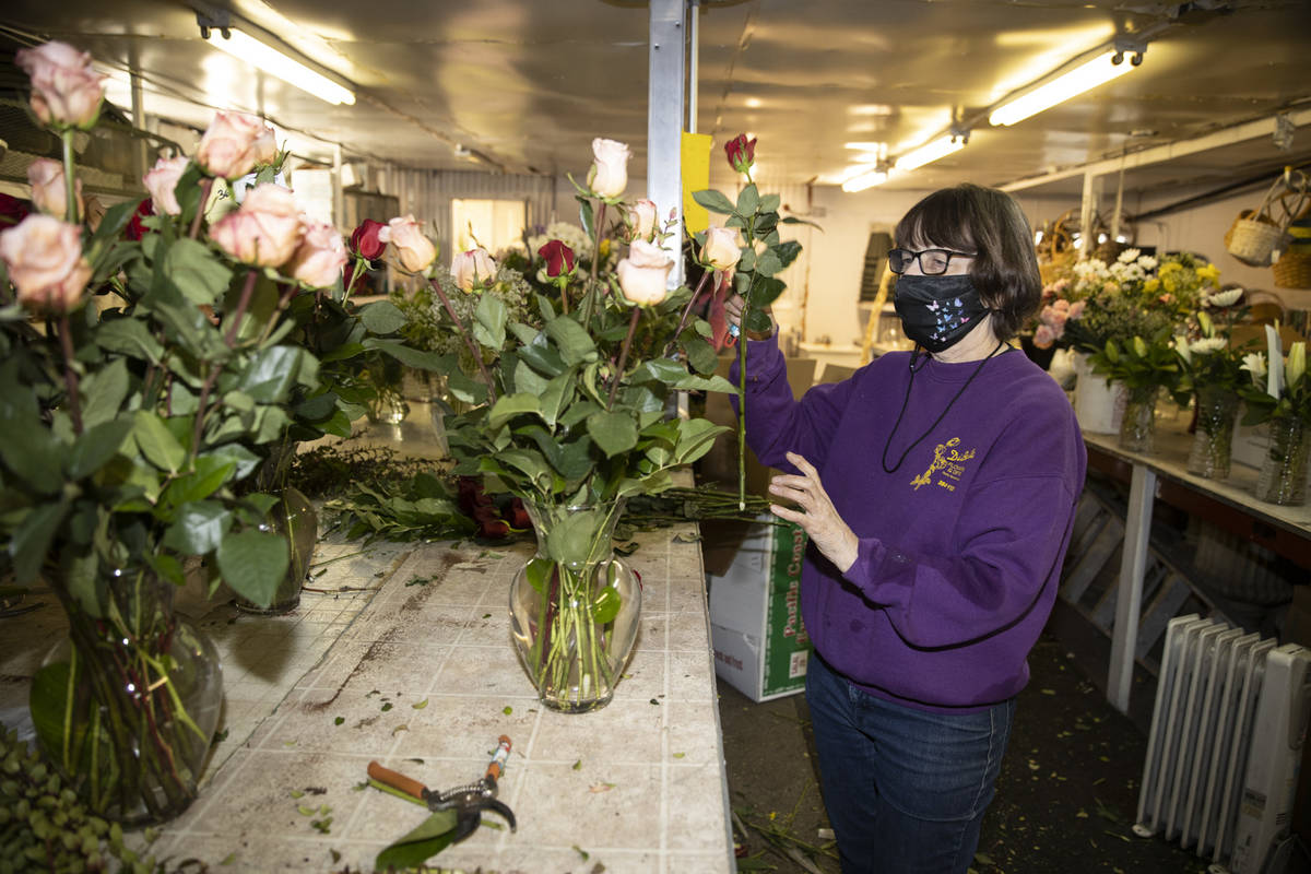 Susan DiBella, co-owner of DiBella Flowers & Gifts, assembles flower bouquets in preparatio ...