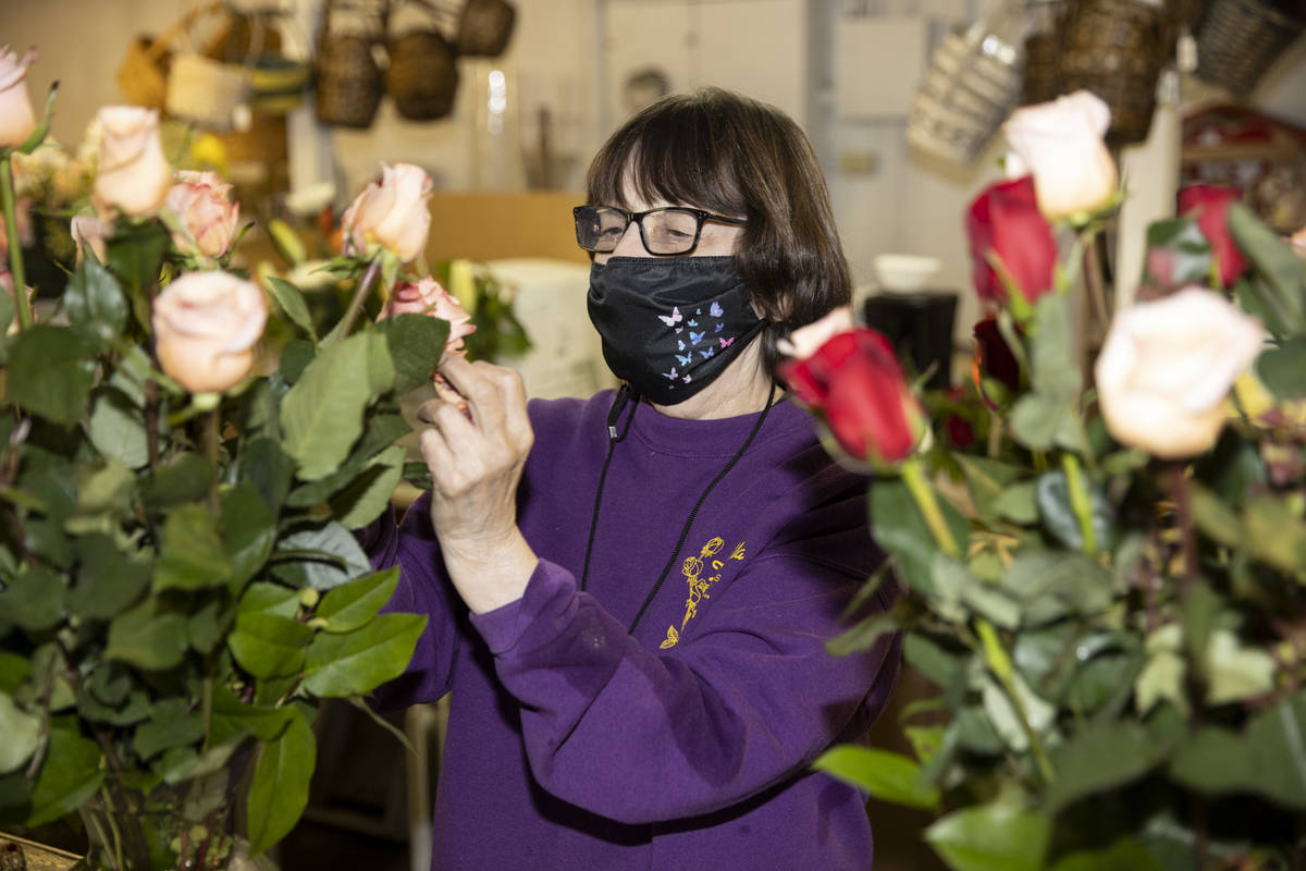 Susan DiBella, co-owner of DiBella Flowers & Gifts, assembles flower bouquets in preparatio ...