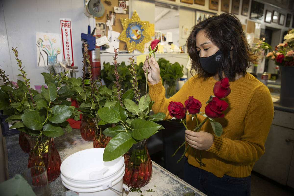 Sales person Kayla Sideco assembles flower bouquets in preparation of Valentine's Day at DiBell ...