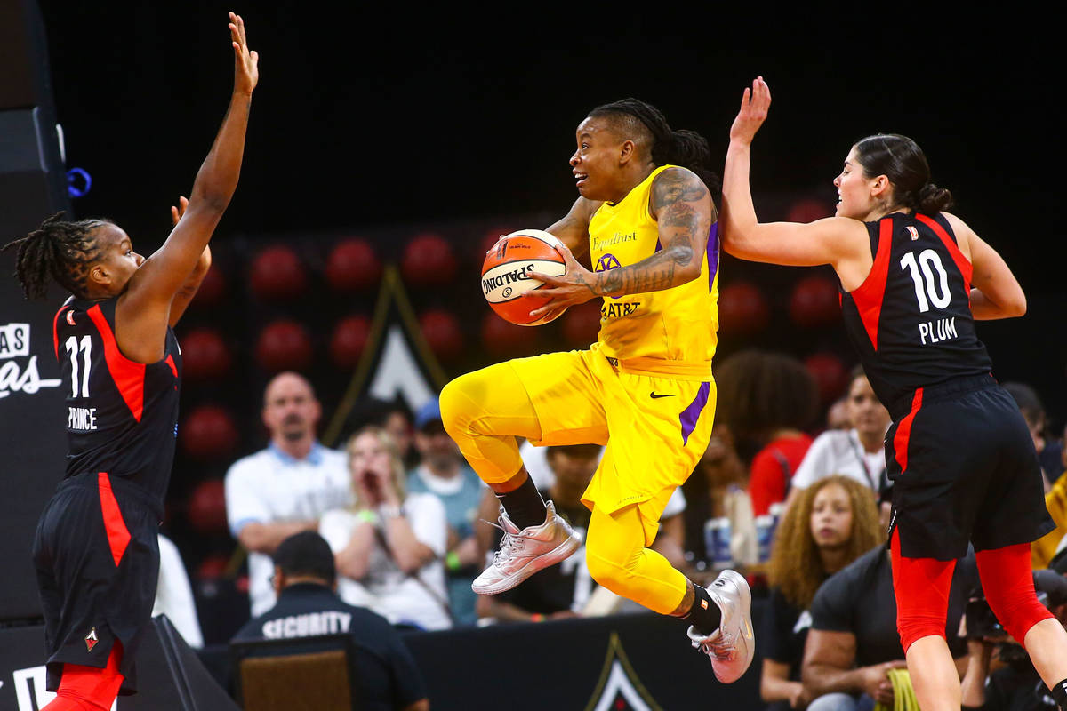 Los Angeles Sparks' guard Riquna Williams goes to the basket between Las Vegas Aces' Epiphanny ...