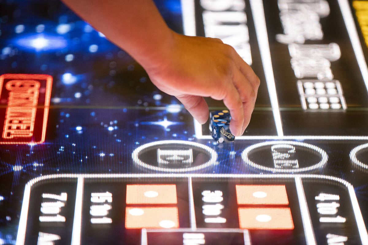 Rio Bencito of Los Angeles gets ready to roll on the new digital craps table, Rolls to Win Crap ...