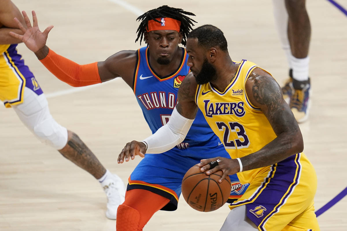 Oklahoma City Thunder forward Luguentz Dort defends against Los Angeles Lakers forward LeBron J ...