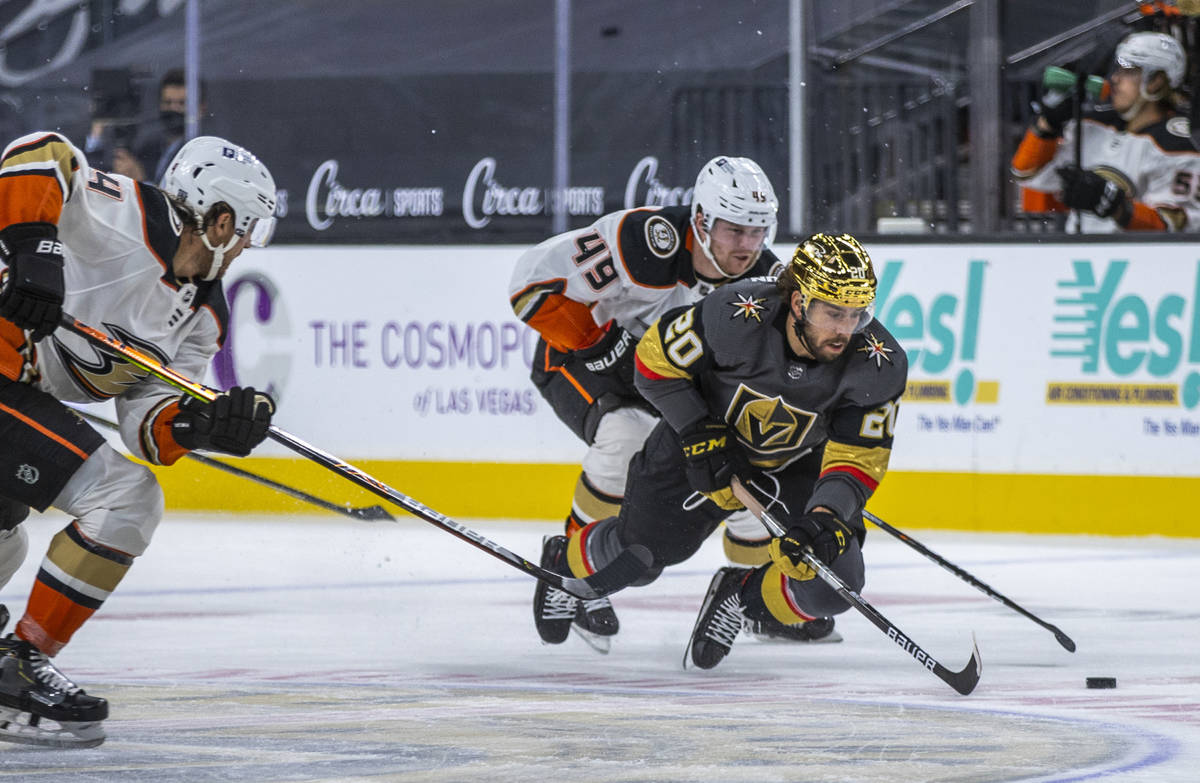 Golden Knights center Chandler Stephenson (20) is tripped up by Anaheim Ducks left wing Max Jon ...
