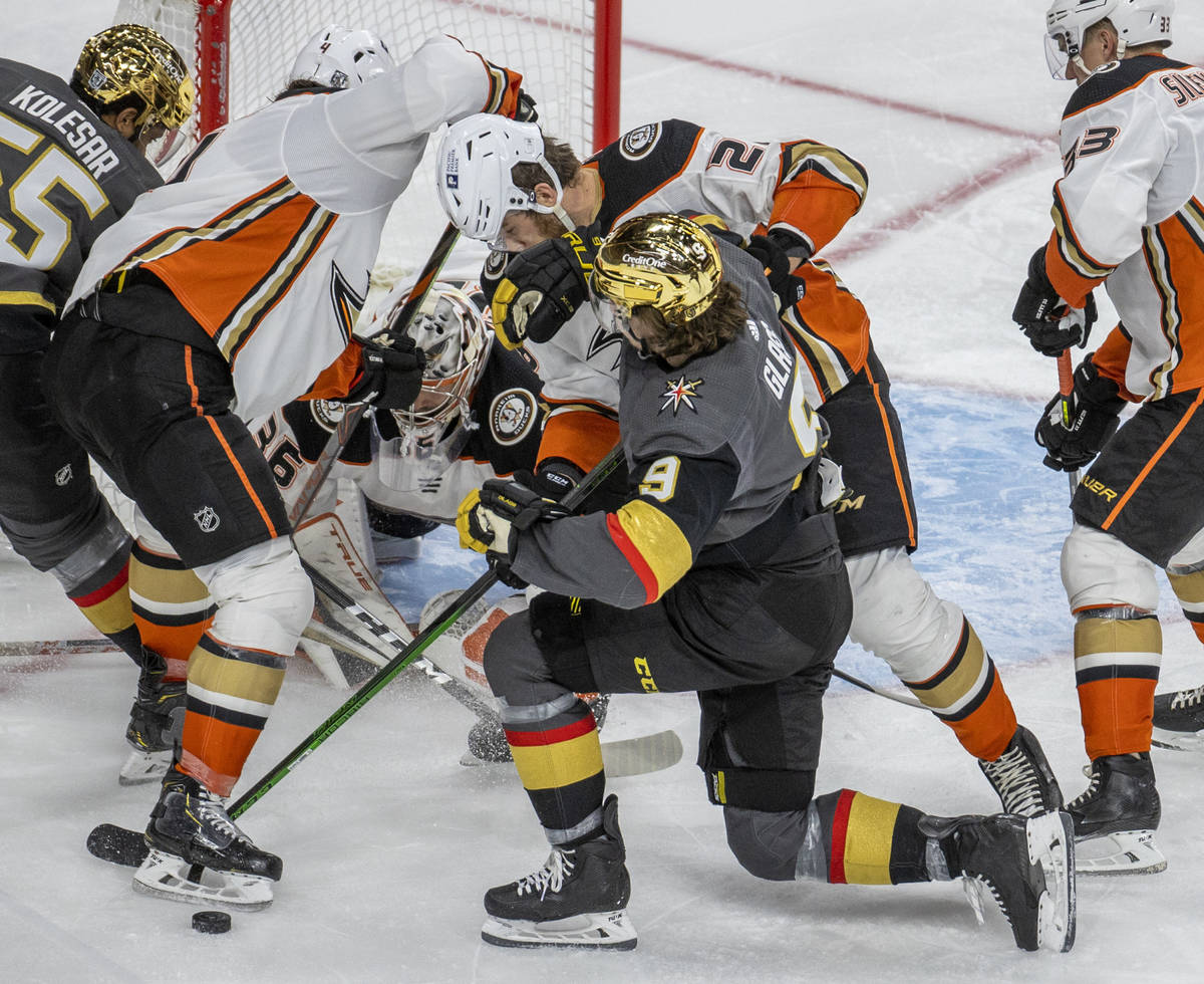 Golden Knights center Cody Glass (9) takes a check from Anaheim Ducks defenseman Jani Hakanpaa ...