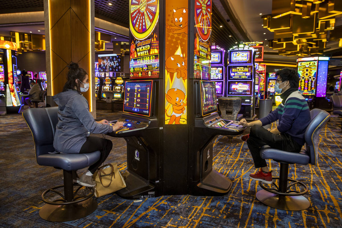 Emily Kluse of Cincinnati, left, and Zaw Naw of Denver play the Hot Stuff Wicked Wheel slots on ...