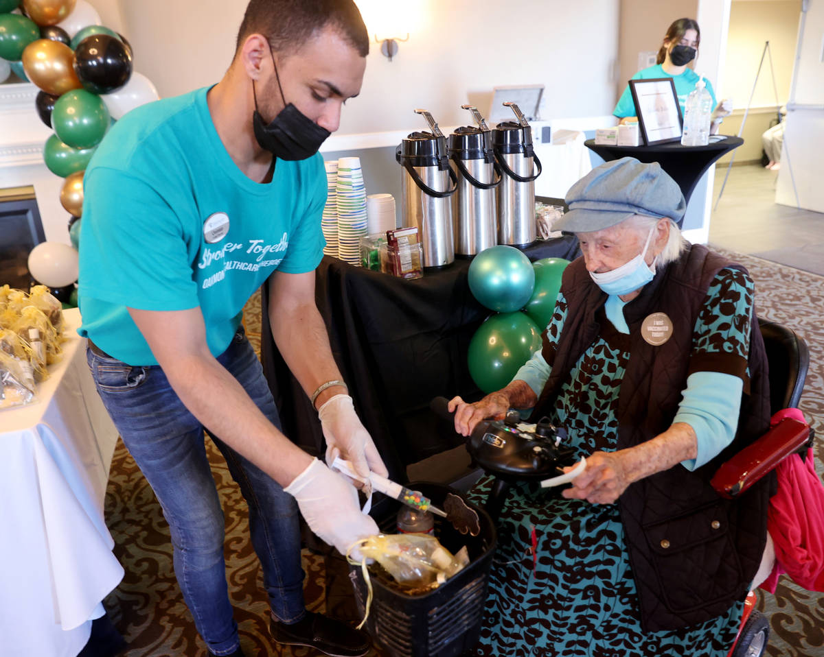 Quintan Brown-Rodrigues gives Valmae Ayres, 98, treats, including a syringe filled with candy, ...