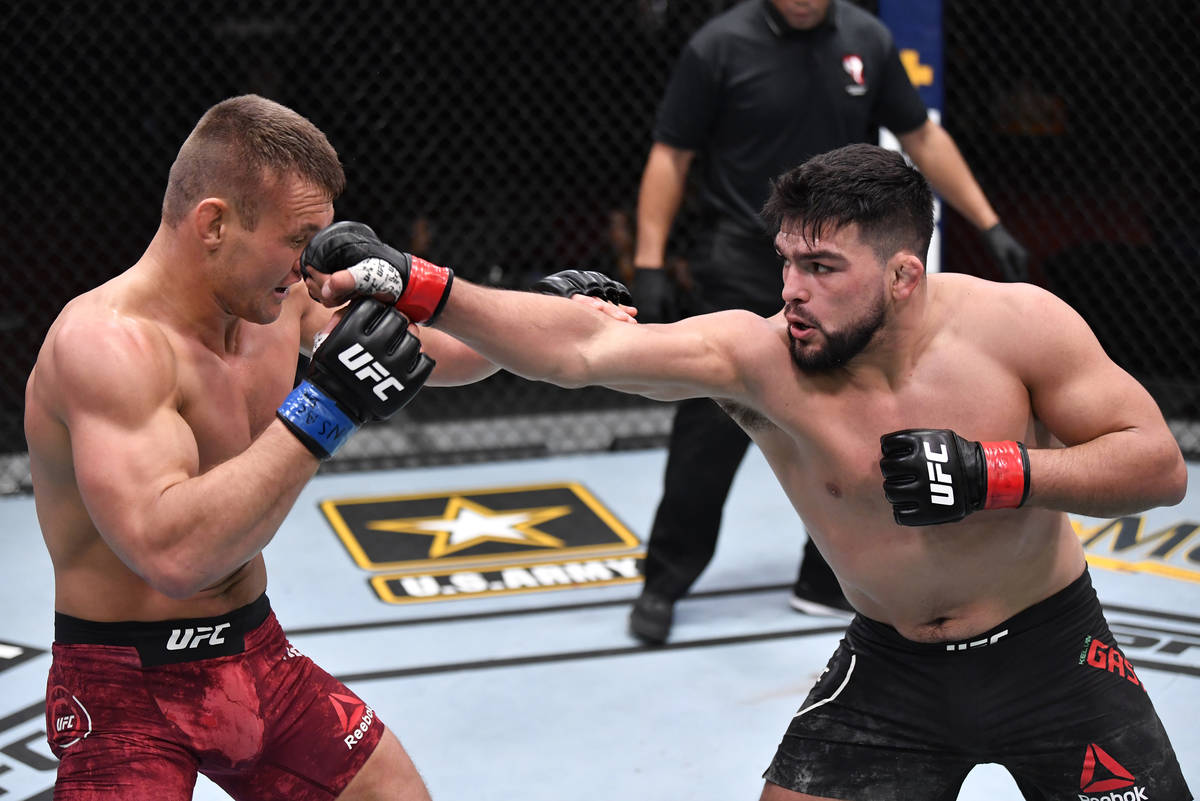 (R-L) Kelvin Gastelum punches Ian Heinisch in their middleweight fight during the UFC 258 event ...