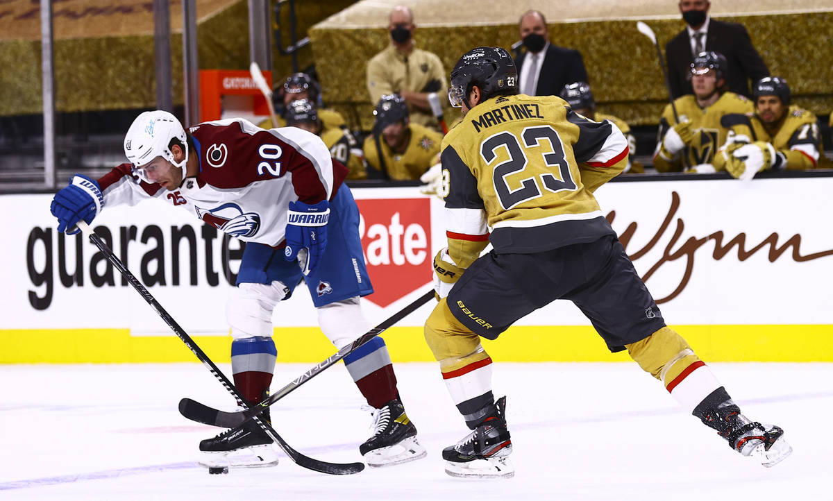 Golden Knights defenseman Alec Martinez (23) and Colorado Avalanche left wing Brandon Saad (20) ...