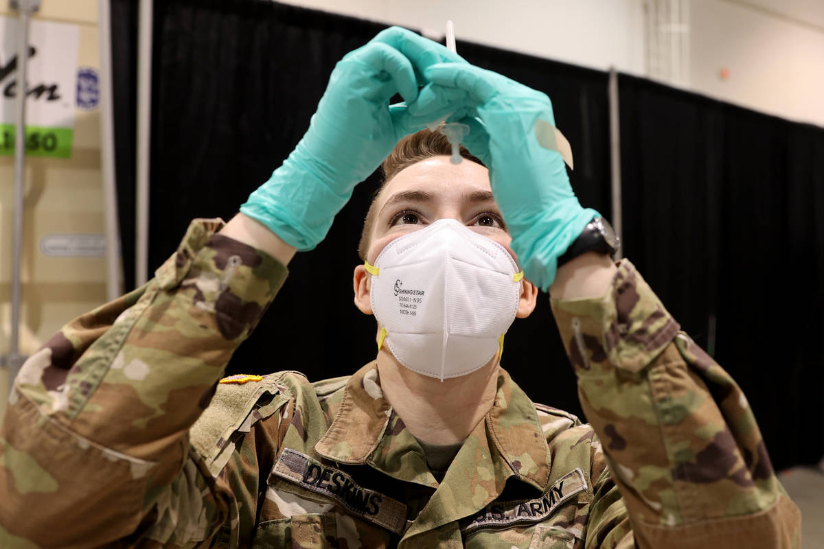 Nevada National Guard Spc. Katherine Deskins prepares to administer a Pfizer vaccine shot at th ...