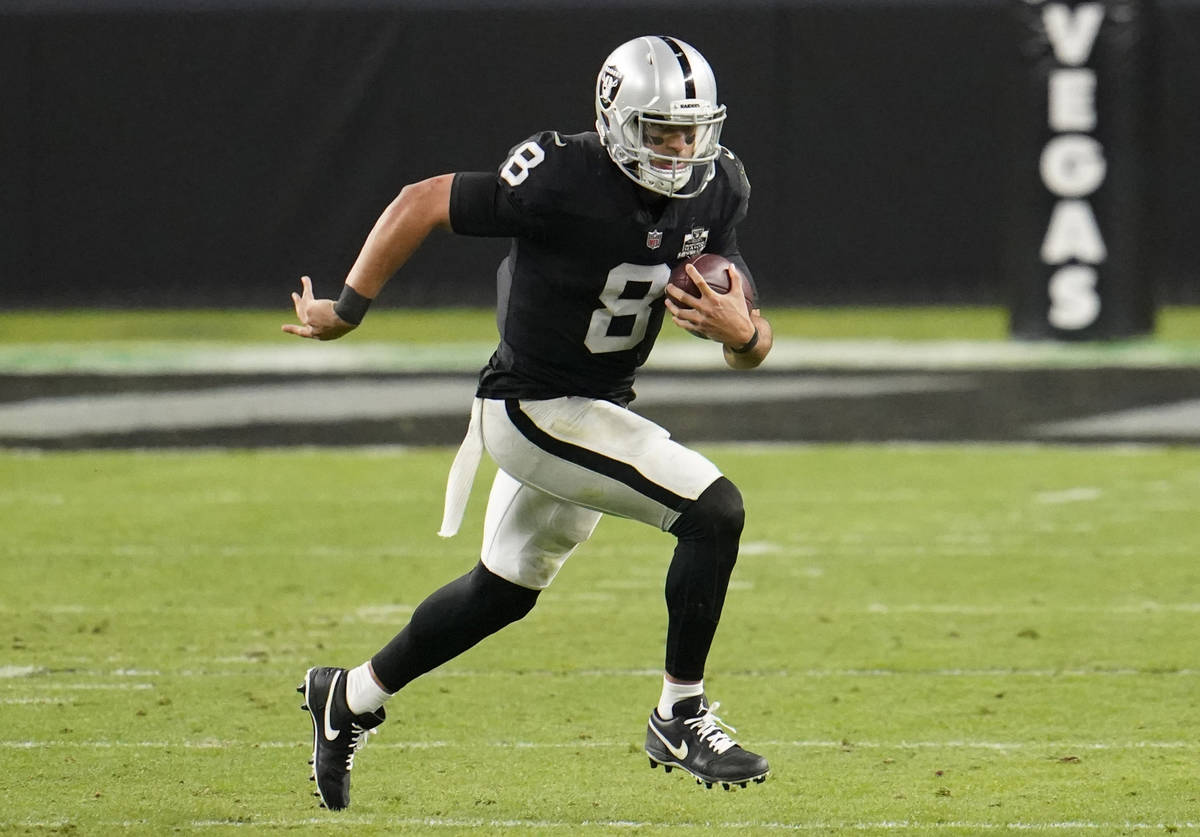 Las Vegas Raiders quarterback Marcus Mariota #8 rushes in overtime against the Los Angeles Char ...