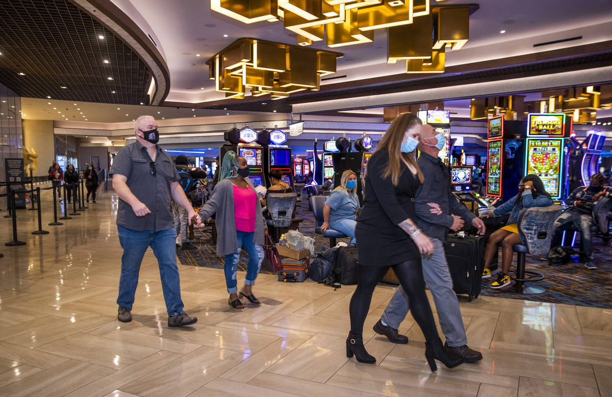 Couples pass by slot machines and the front desk area as casino floors have moved up to 35% occ ...