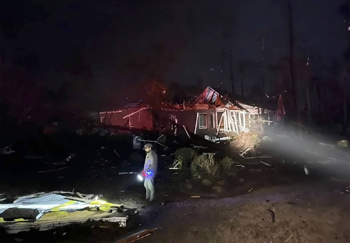 A man surveys the damage after a deadly tornado tore through Brunswick County, N.C., Tuesday, F ...