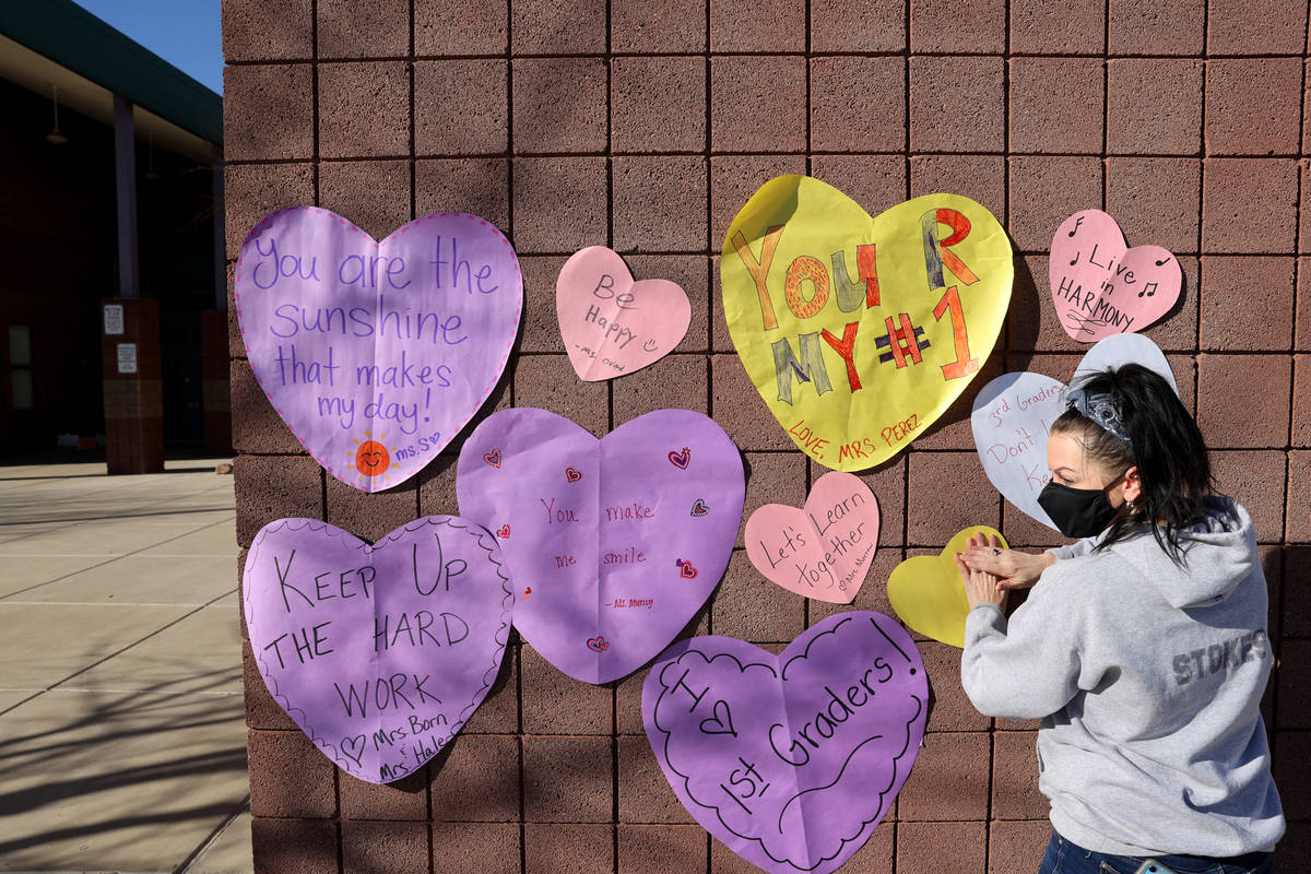 Kirsten Stokes, a K-5 instructional coach, decorates during a school supply distribution event ...