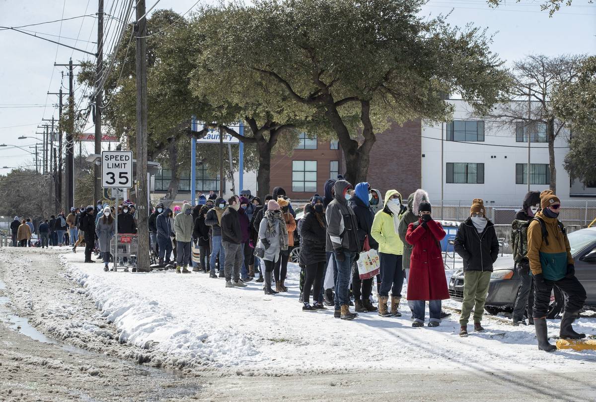 People wait in a long line to buy groceries at H-E-B on South Congress Avenue during an extreme ...