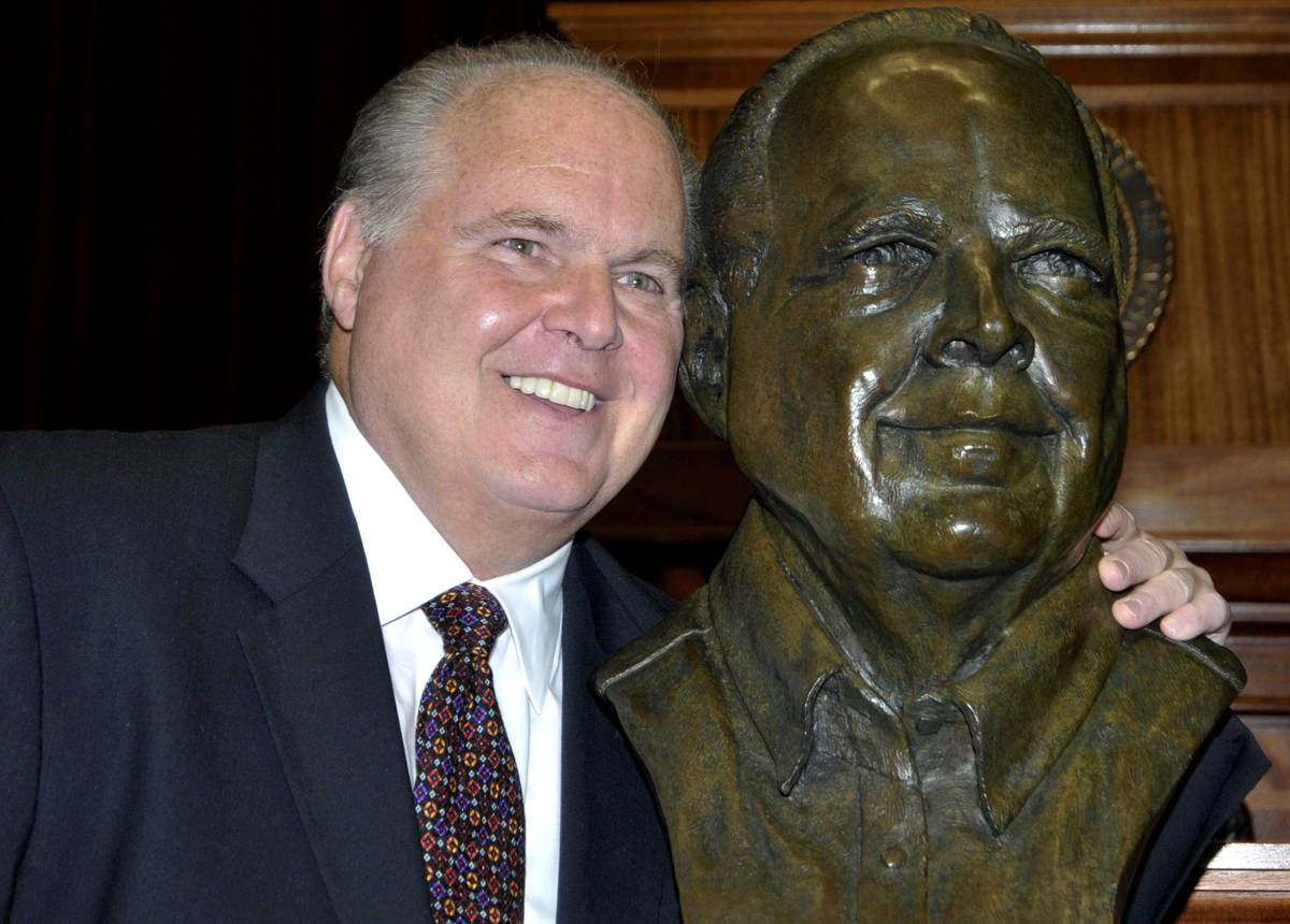 FILE - In this May 14, 2012 file photo, conservative commentator Rush Limbaugh poses with a bus ...
