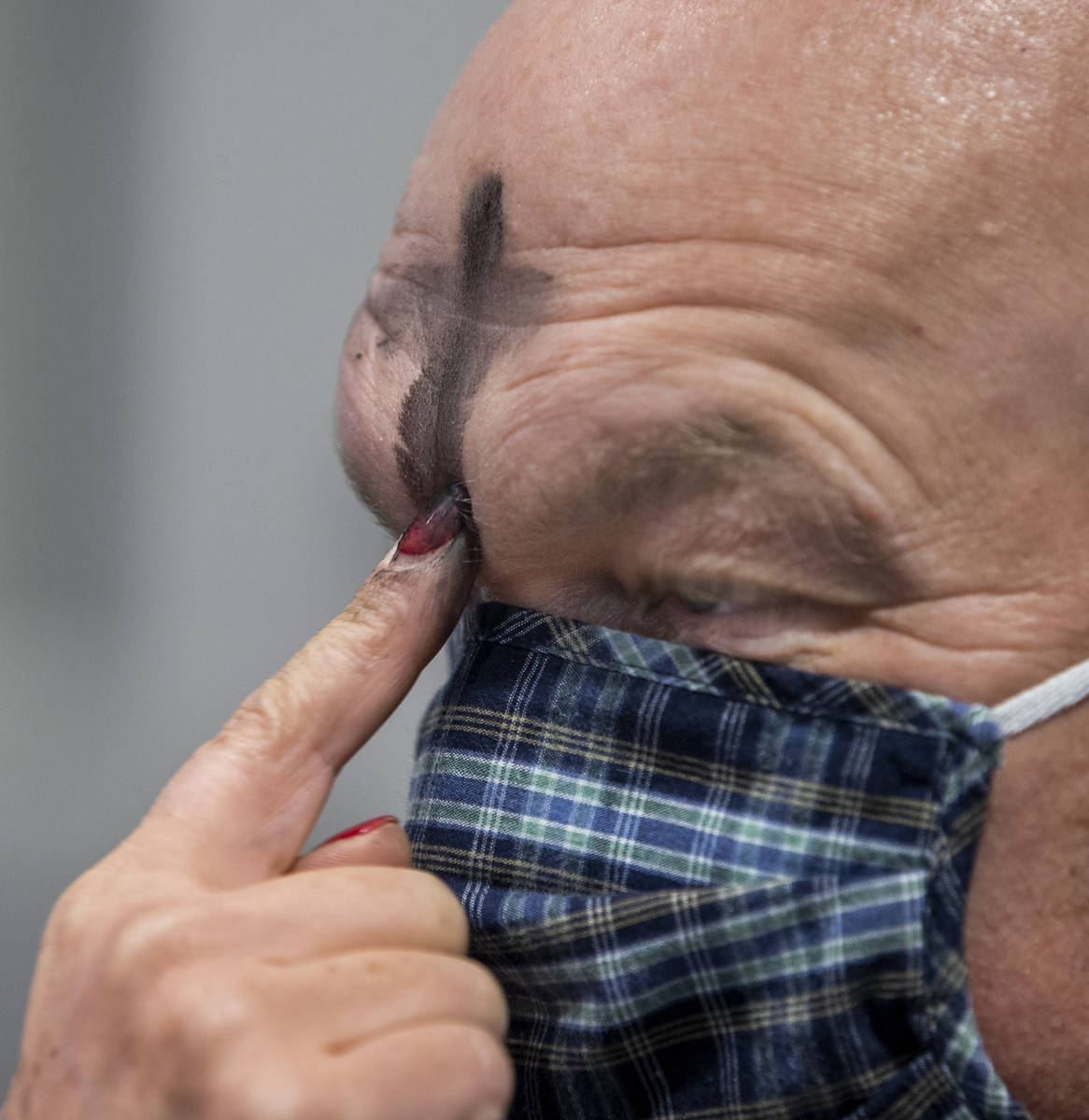 Matt Flandermeyer has ashes placed in the sign of a cross on his forehead by wife Shelley durin ...